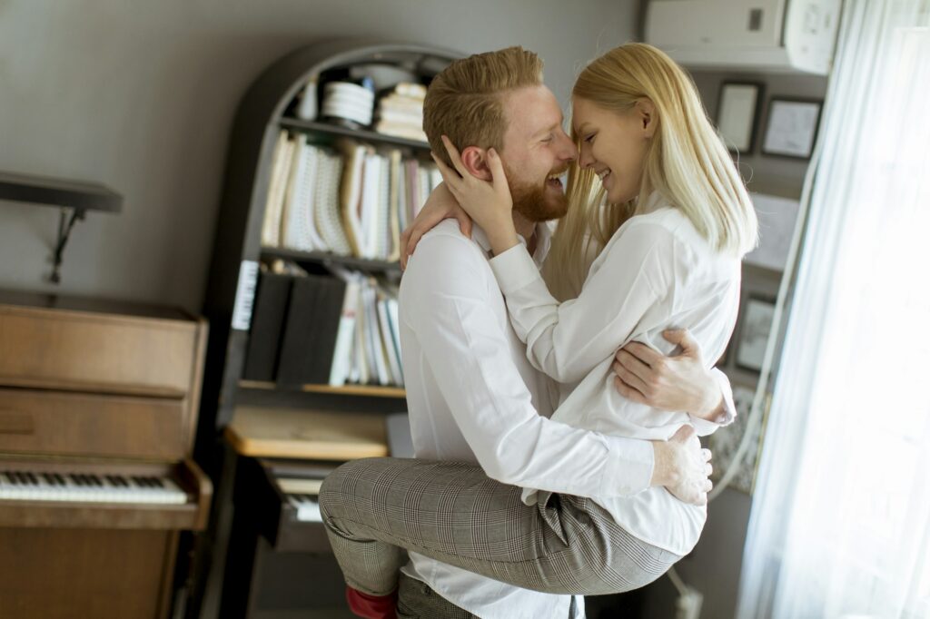 Loving young couple kissing in the room