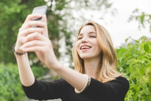 Young woman using smartphone taking selfie